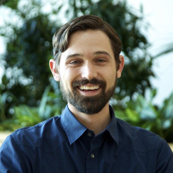 man with dark hair in a blue button-down shirt