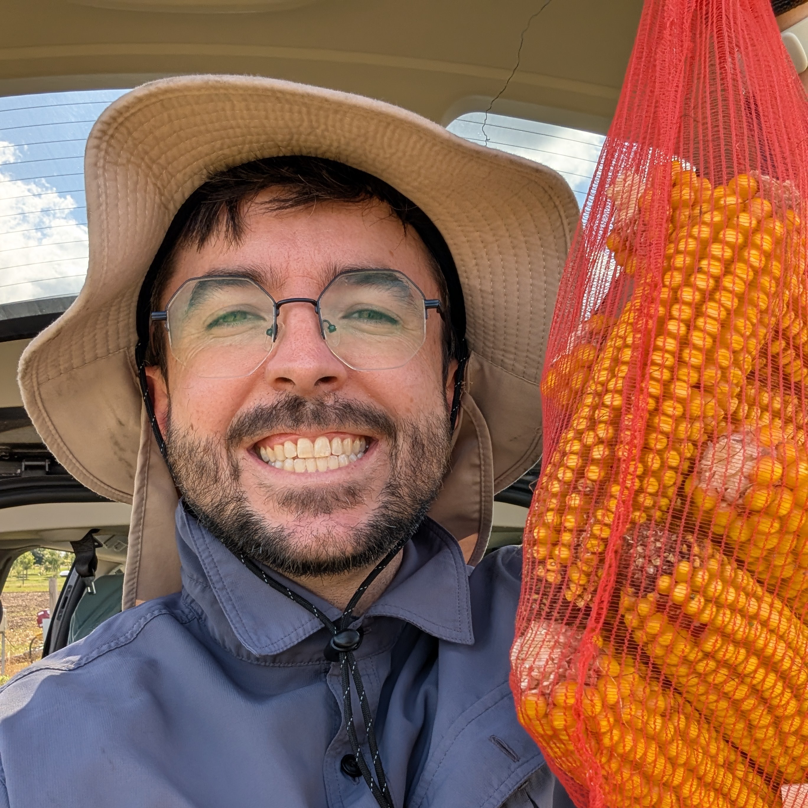 Man holding a bag of corn & smiling at the camera